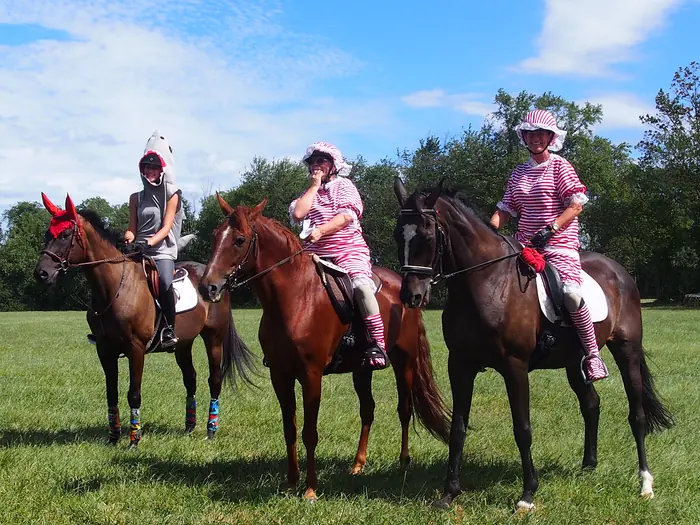 Riders in costume lined up on horseback in a field at the farm